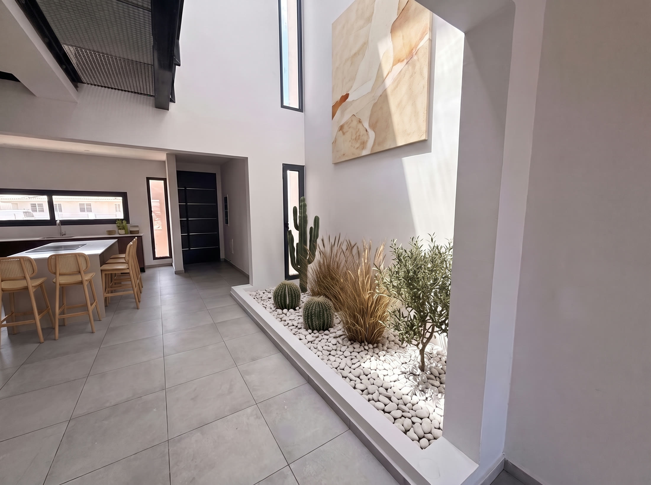 Full-height atrium with a sunken planting bed of cacti and pebbles