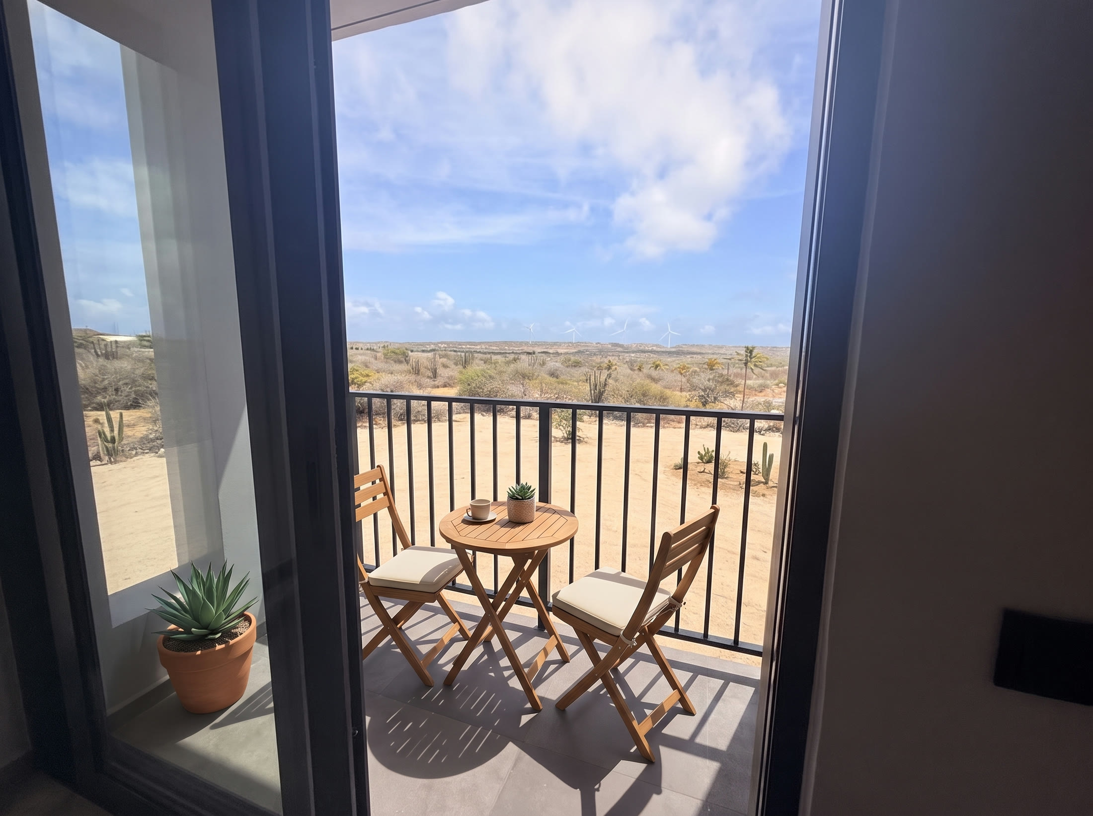 Small balcony with two teak chairs and a bistro table