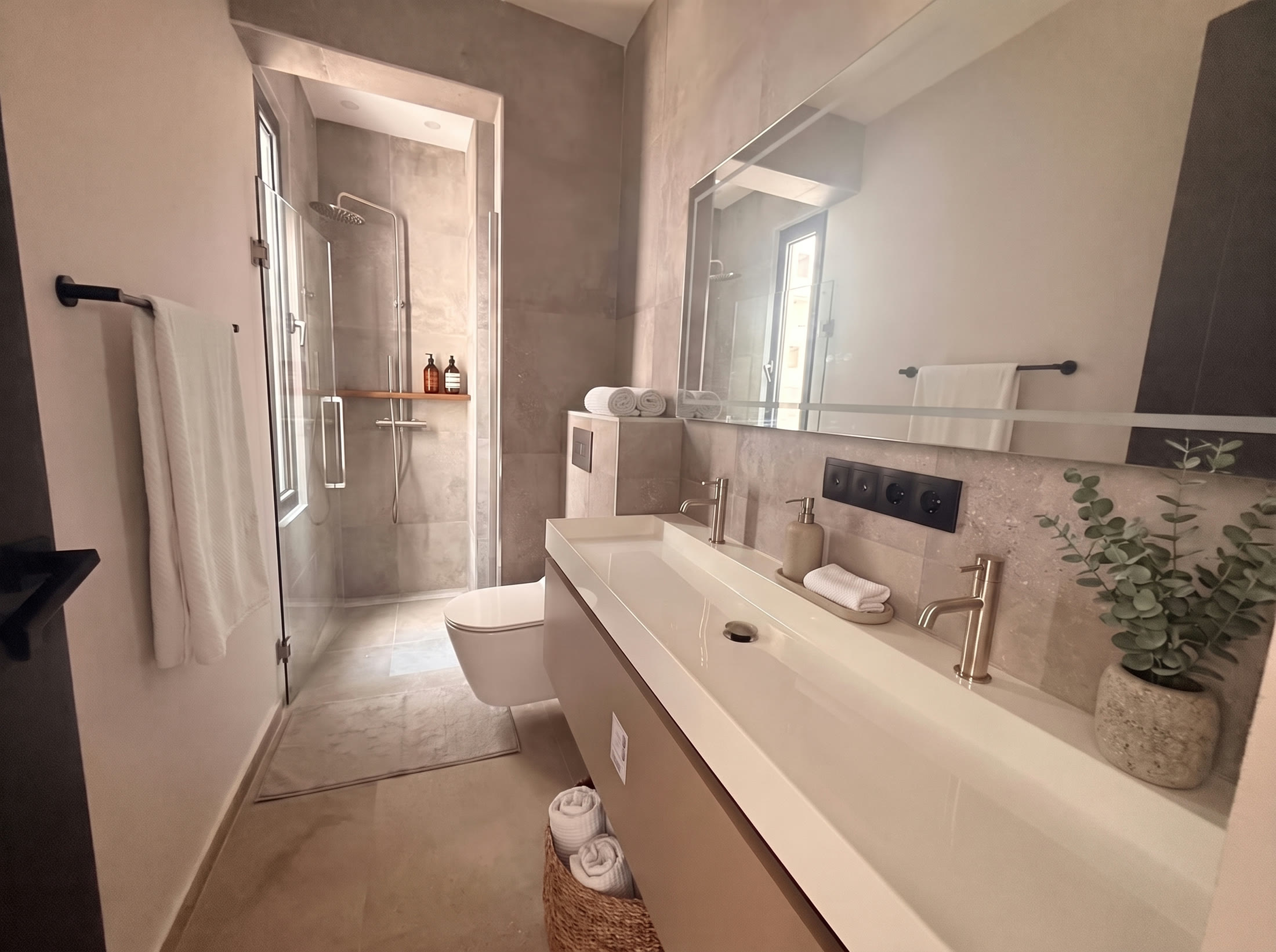 Bathroom with long trough washbasin, mirror and walk-in shower